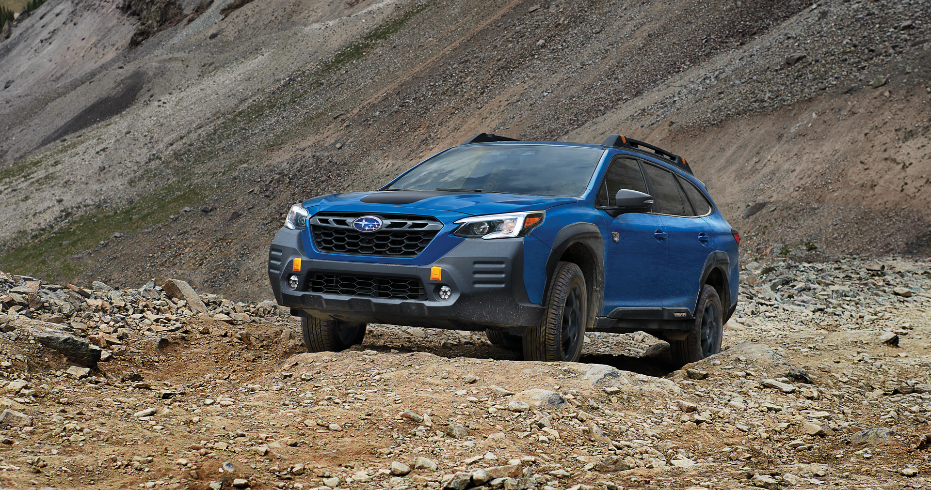 A 2023 Outback Wilderness driving on a trail in the mountains. | Subaru of Grand Blanc in Grand Blanc MI