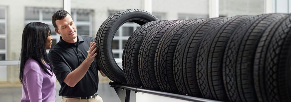 Subaru service representative showing customer a tire. | Subaru of Grand Blanc in Grand Blanc MI